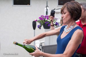 The birthday girl trying her hand at sabering a bottle of bubbly.