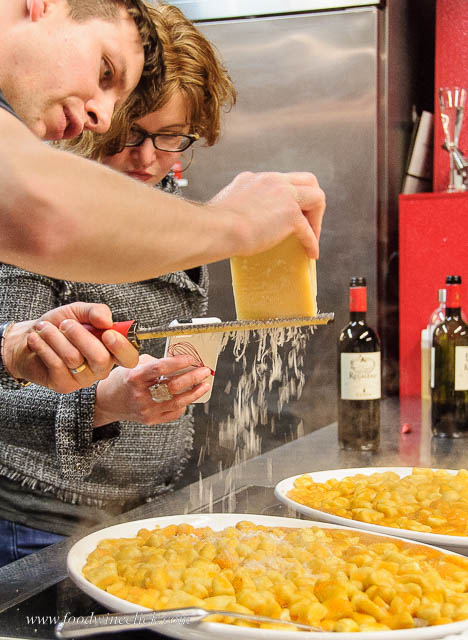Grating Parmigiano Reggiano over fresh ricotta gnocchi