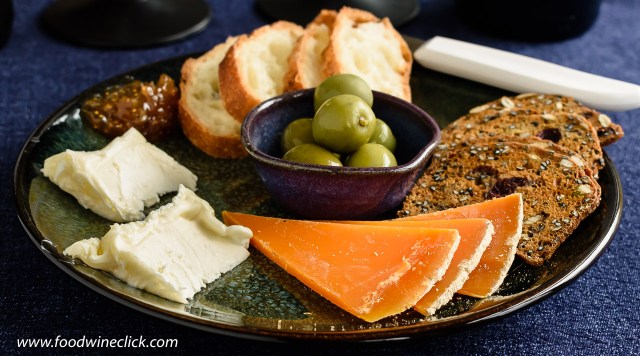 A cheese plate featuring St. Nuage and Mimolette cheeses from France